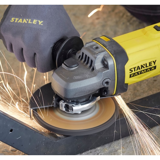 STANLEY SFMCG400M2K angle grinder in use, grinding metal with sparks, close-up view.