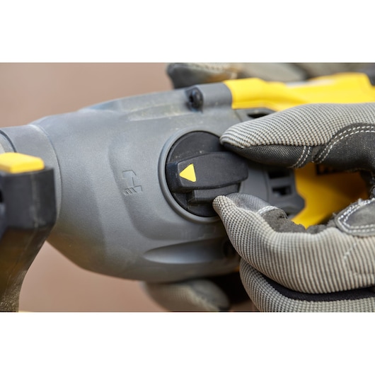 STANLEY SFMCH900M12 rotary hammer mode selector close-up, gloved hand turning switch.