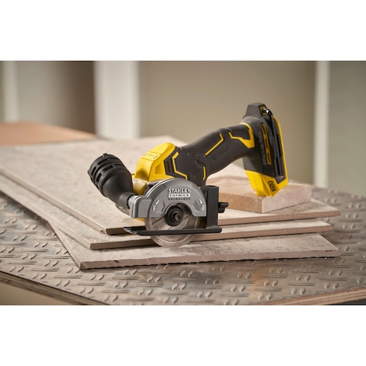 STANLEY SFMCM300B cordless circular saw on tiles, side angle, black and yellow design.