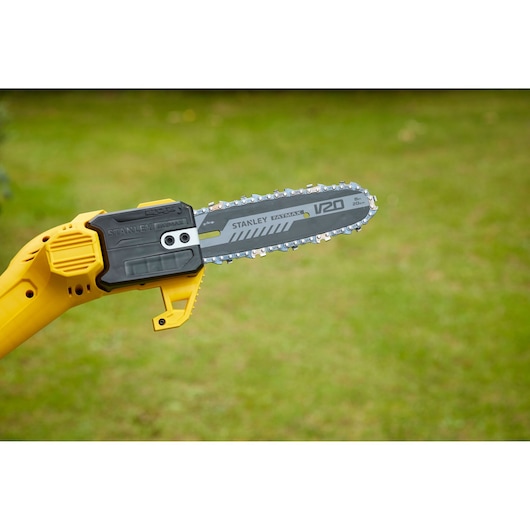 STANLEY SFMCPS620B pole saw with yellow handle and gray blade outdoors on grass.
