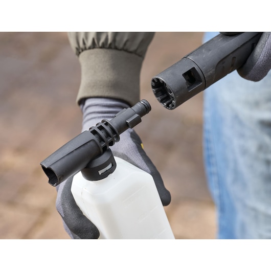 STANLEY SFMCPW1500B foam bottle attachment for pressure washer, close-up view held in hand.