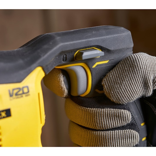 Photo of STANLEY SFMCS300D1K power tool handle with glove, close-up on trigger and V20 marking.