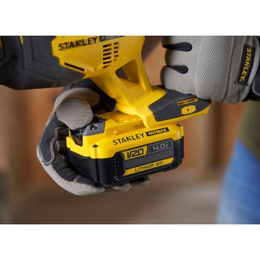 Photo of STANLEY SFMCS300M1K saw being held by gloved hands, highlighting V20 4.0Ah lithium-ion battery.