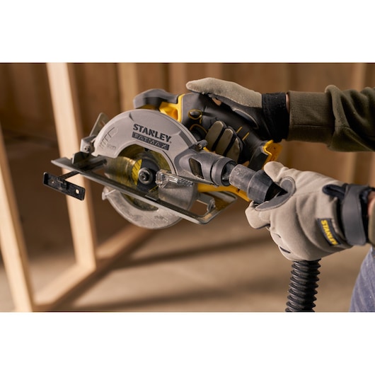 STANLEY SFMCS500D1K circular saw held by gloved hands in workshop setting.