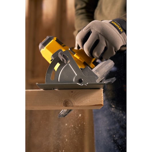 STANLEY SFMCS500M1K circular saw cutting wood, close-up action shot, worker wearing STANLEY branded gloves.