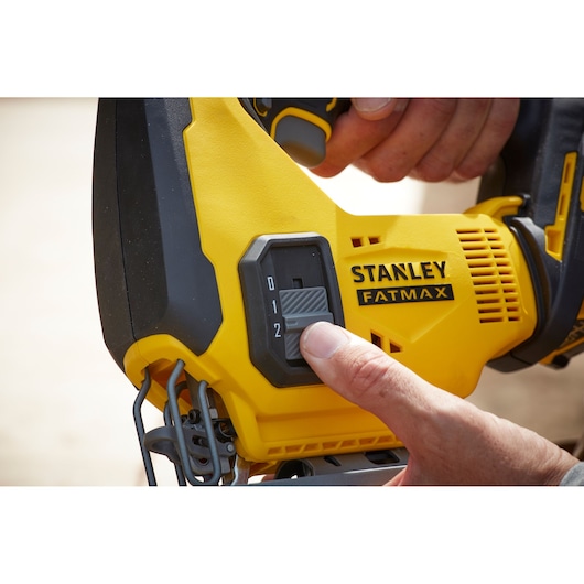 Photo of STANLEY SFMCS600D1K FATMAX jigsaw speed control being adjusted by hand, close-up.