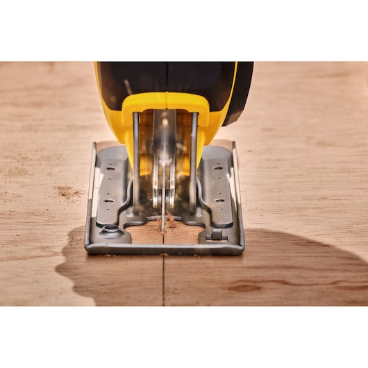 STANLEY SFMCS600D1K jigsaw cutting wood, close-up front angle.
