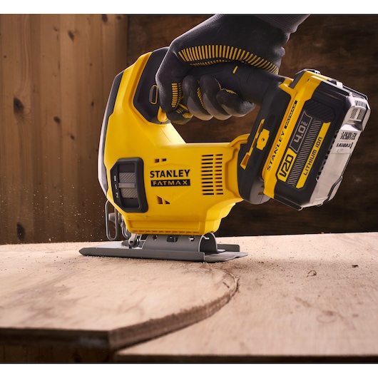 STANLEY SFMCS600M1K jigsaw, yellow cordless tool cutting wood, close-up, FATMAX branding visible.