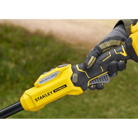 Photo of STANLEY SFMSTB930M brushless tool handle in yellow and black held by gloved hand outdoors.