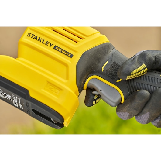 STANLEY STCSS20D1 cordless tool handle close-up held by gloved hand, yellow and black design.