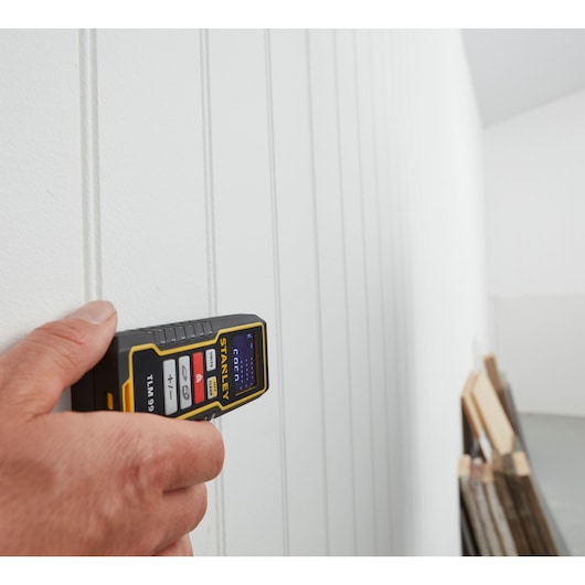Photo of STANLEY STHT1-77138 laser distance meter used to measure a white paneled wall.
