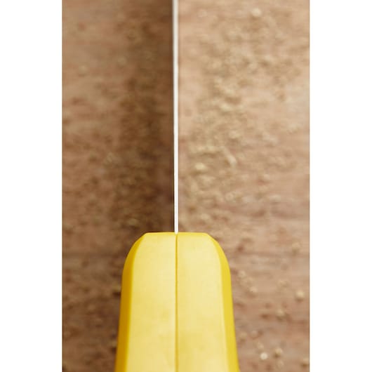 Photo of STANLEY STHT20371-1 hand saw with yellow handle, blade cutting through wood, top view.