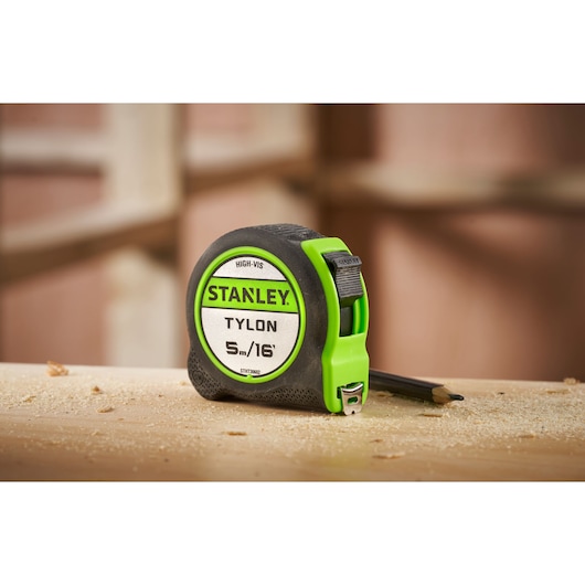 Stanley STHT30602-1 Tylon tape measure, high-vis green and black, shown on a workbench with pencil.