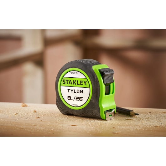 STANLEY STHT30604-1 Tylon 8m/26ft tape measure with green accents on a wooden surface.