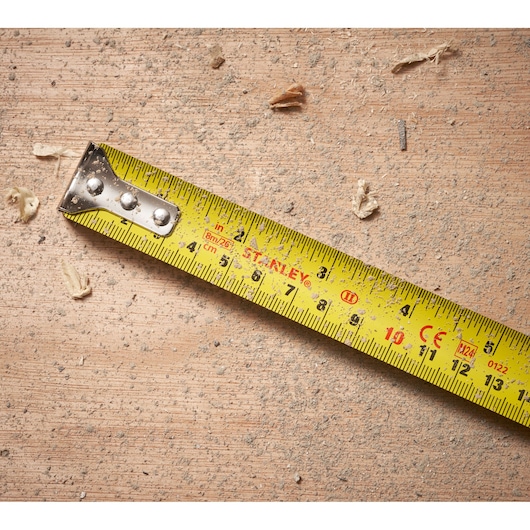 STANLEY STHT30604-1 yellow tape measure close-up on dusty wood surface.