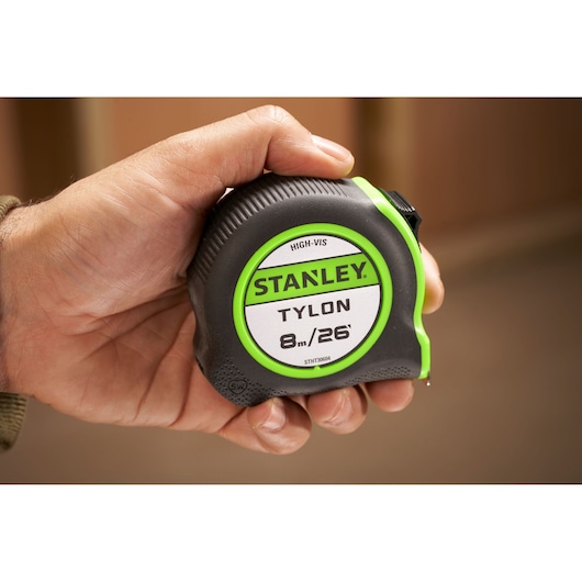 Photo of STANLEY STHT30604-1 Tylon 8m/26ft tape measure held in hand, black and green casing.