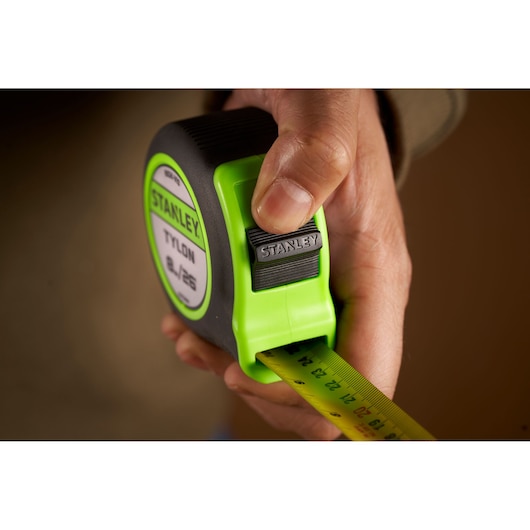 Stanley STHT30604-1 green and black tape measure held in hand, close-up photography.