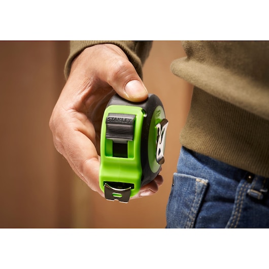 STANLEY STHT30604-1 green and black tape measure held in hand, close-up view.