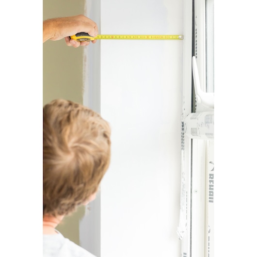 STANLEY STHT36806-0 tape measure held horizontally against white wall near window.