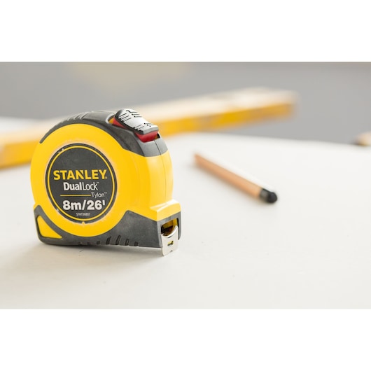 STANLEY STHT36807-0 tape measure DualLock Tylon 8m/26ft on tabletop with pencil in background.