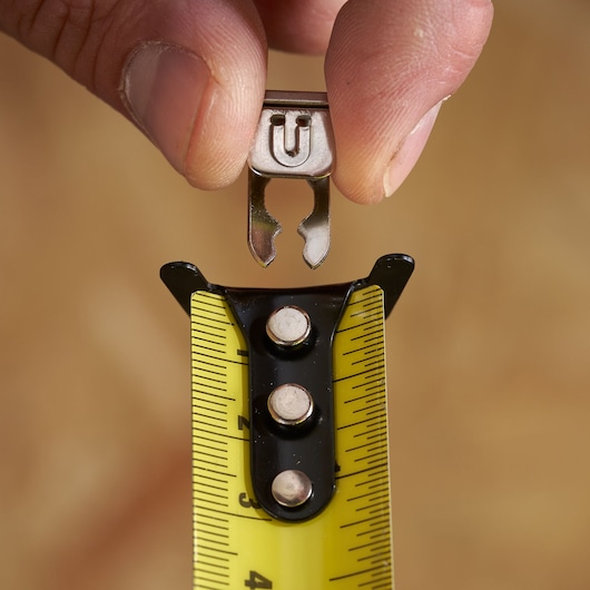 STANLEY STHT37237 tape measure end hook in close-up, yellow blade and black markings, photography.