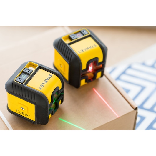 STANLEY STHT77498-1 photography of two yellow and black Cubix laser levels projecting green and red lines.