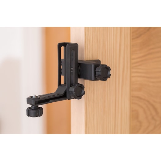 STANLEY STHT77503-1 photography door clamp mount in black, attached to light wood surface, side angle.
