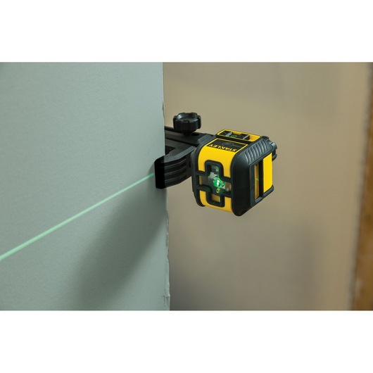 STANLEY STHT77592-1 laser level tool projecting green line on wall, mounted with clamp.
