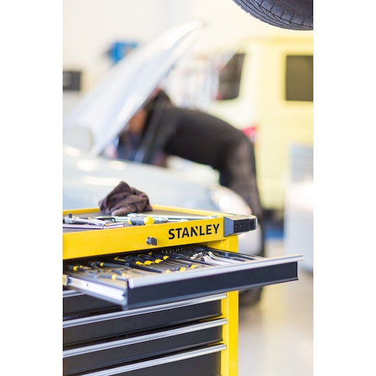 STANLEY STMT1-74306 tool chest with open drawer showing hand tools, garage workshop setting.