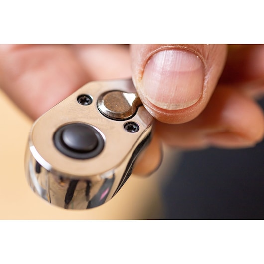 Close-up of hand operating STANLEY STMT82663-0 ratchet wrench thumb switch.