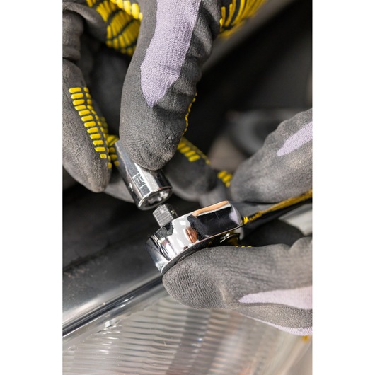 STANLEY STMT82663-0 socket and ratchet tool held by gloved hands, close-up during use.