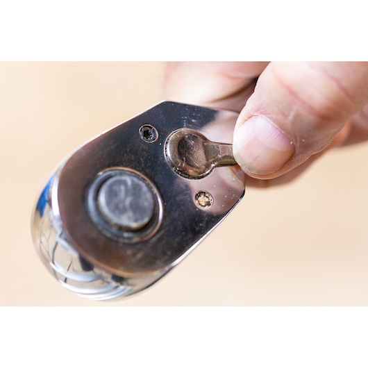 STANLEY STMT82664-0 ratchet head close-up, showing a hand adjusting the switch, photography product.