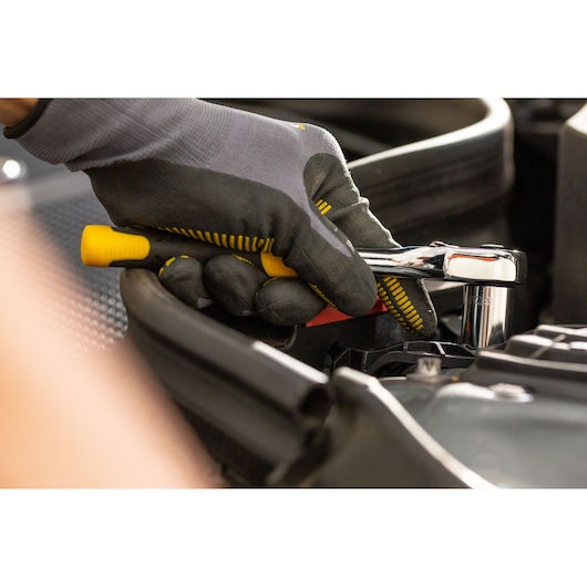 STANLEY STMT82664-0 ratchet wrench in use, close-up photo of hand with glove, automotive context.
