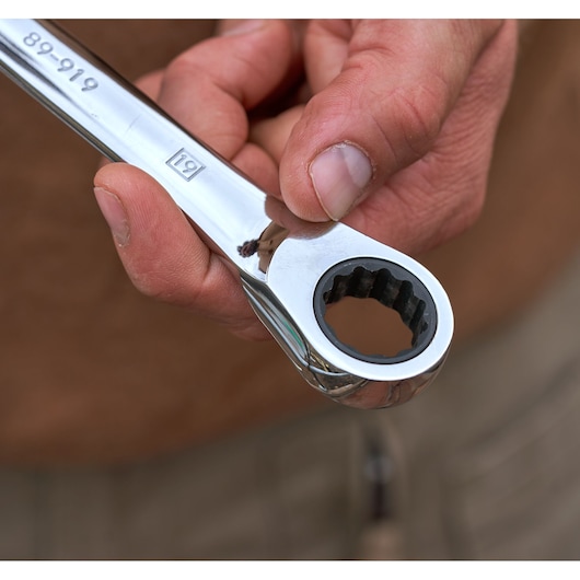 Close-up photo of a hand holding a STANLEY flat ratcheting wrench, SKU STMT82846-0, showing the ratcheting end.