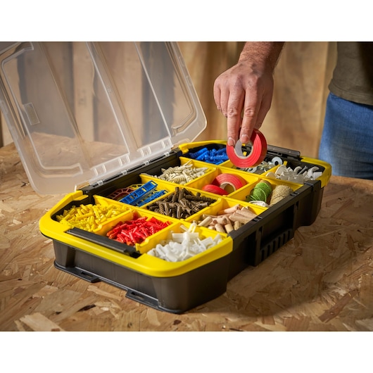 STANLEY STST1-71983 organizer box with yellow compartments filled with assorted hardware, angled view.