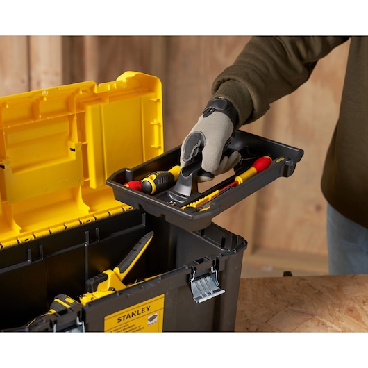 STANLEY STST75787-1 tool box with yellow lid, removable tray, hand holding tray with tools, side angle