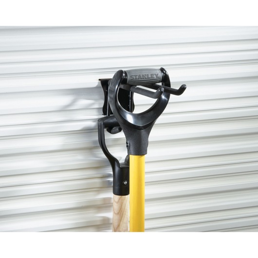 STANLEY STST82606-1 black steel wall-mounted tool holder with yellow-handled tool, side angle.