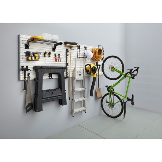 STANLEY STST82611-1 photography of wall-mounted garage organizer with tools and green bike, side angle.