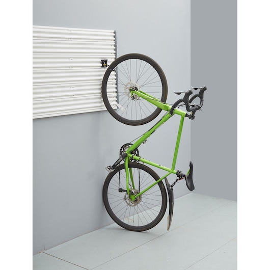 STANLEY STST82616-1 wall panel with green bike mounted vertically, indoor garage organization.
