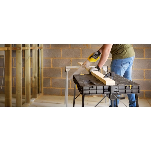 STANLEY STST83492-1 workbench used for woodworking, black plastic table, woodworking clamp, indoor workshop.