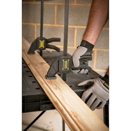 Stanley STST83492-1 photography of bar clamps securing wood on a workbench in workshop setting.