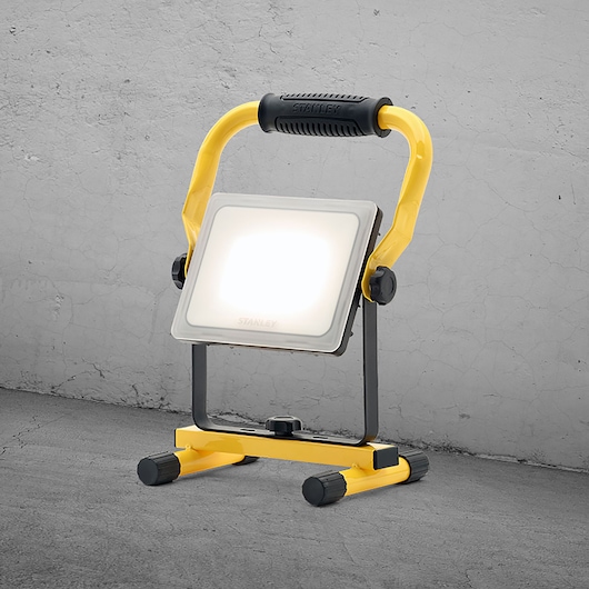 STANLEY SXLS36384E LED work light with yellow handle, front angle, on concrete floor.