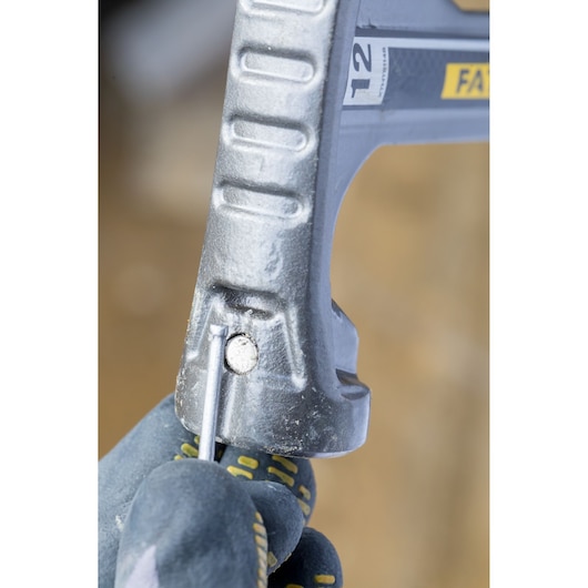 STANLEY XTHT1-51148 hand saw close-up showing adjustment mechanism, worker with gloves adjusting blade.